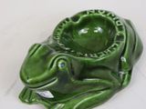 a green frog shaped ashtray on a white table
