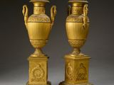 deux vases en or empilés l'un sur l'autre, posés sur une table