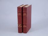 two red books sitting on top of each other on a white surface