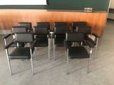de nombreuses chaises noires dans une pièce aux murs verts