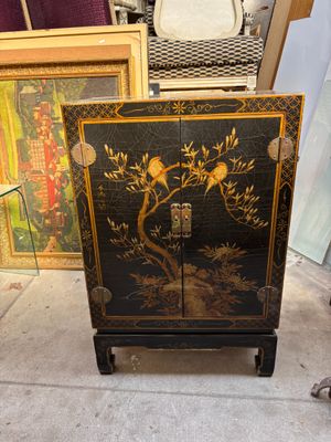 une armoire noire ornée d'un motif représentant un oiseau
