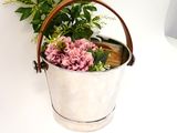 a bucket with flowers in it sitting on a table