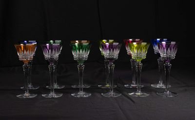 seven wine glasses lined up in a row on a table