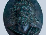 a close up of a bronze medallion with a man ' s face