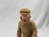 a toy figure of a man in a trench coat and hat