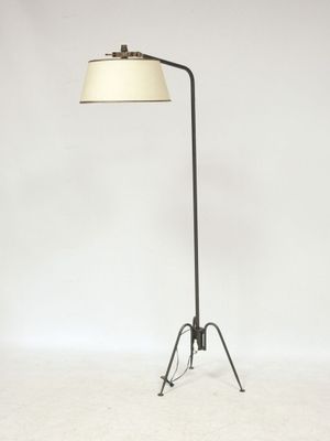 a black floor lamp with a white shade on top of it