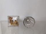 a small glass container with a gold object inside of it