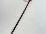 an old cane with a wooden handle on a white surface