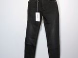 le mannequin tient un jean noir sur un pied de mannequin