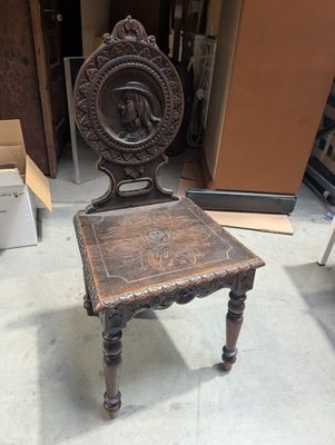 une chaise en bois qui se trouve au milieu d'une pièce