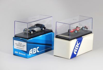 deux voitures miniatures dans une vitrine posée sur une table