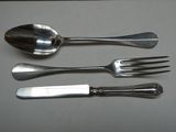 trois fourchettes, une cuillère et un couteau posés sur une table