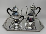 two silver teapots on a silver tray on a table