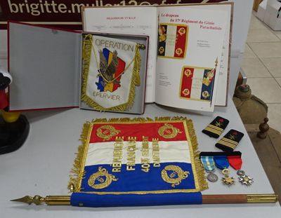 une table sur laquelle sont posés un gâteau, une médaille et d'autres objets