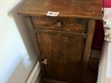 une petite table sur laquelle est posée une lampe, dans un coin de la pièce