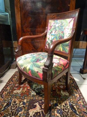 a chair with a colorful upholstered seat on a rug
