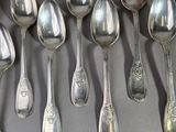 a lot of spoons and forks laid out on a table