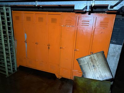 an orange locker in a room with a lot of lockers