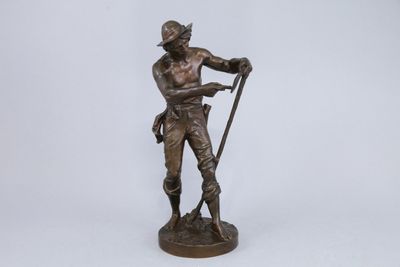 a bronze statue of a man with a cane and hat