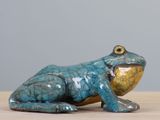 une figurine de grenouille bleue posée sur une table en bois