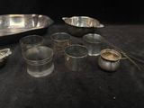 a lot of silver dishes and cups on a black table