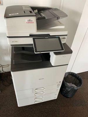 une imprimante posée sur une pile de papiers