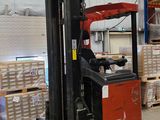 un chariot élévateur dans un entrepôt où se trouvent des palettes et des cartons
