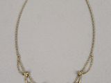 un collier plaqué or orné de fleurs et de feuilles sur une chaîne