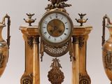 three vases and a clock with an eagle on top