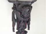 a wooden shelf with a face on it on the wall