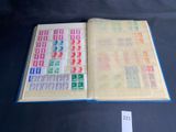 an open book with stamps on it sitting on top of a table