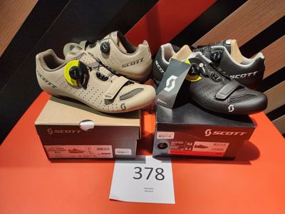 two pairs of shoes are sitting on a table next to a box