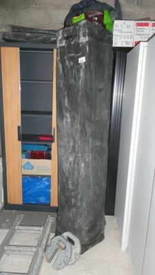 un sac noir posé par terre à côté d'une porte