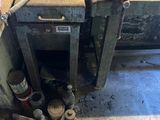 a dirty stove in a dirty room with tools on the floor