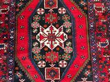 a red and blue rug with a diamond design on it