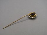 an image of a gold and pearl broochle pin with pearls on it