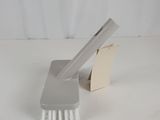 a close up of a brush on a white surface with a white background