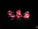 un ensemble de trois diamants roses posés sur une surface noire