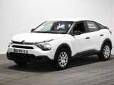 La voiture blanche est garée dans une pièce dont le sol est en damier.