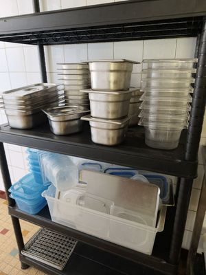many pots and pans on a shelf in a kitchen