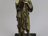 bronze statue of a woman holding a bird on a marble base