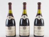 three bottles of wine are lined up on a white surface