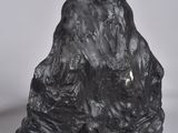 a black sculpture of a mountain on a white surface