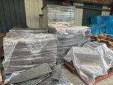 Plusieurs palettes de métal sont empilées les unes sur les autres dans un entrepôt.