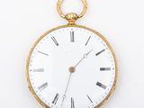 a gold pocket watch with roman numerals on the face
