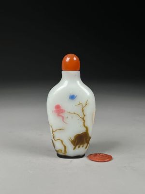 a small glass bottle with a painting on it
