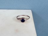 un gros plan d'une bague en argent sertie d'une pierre bleue