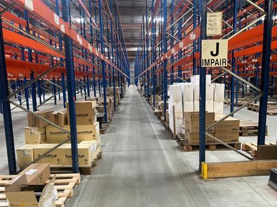 un grand entrepôt rempli de cartons et de palettes