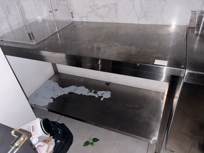 a dirty sink in the corner of a kitchen