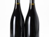 two bottles of wine sitting next to each other on a white surface